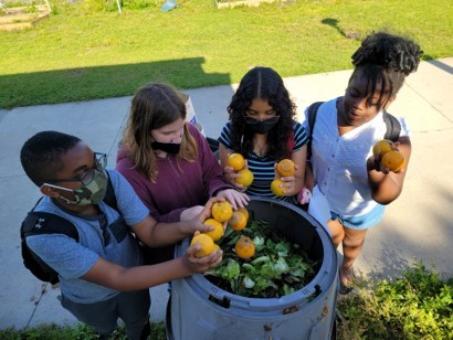 Kids putting food waste into compost bins